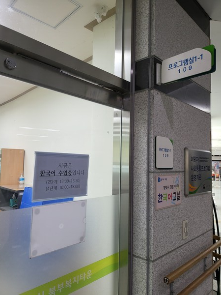 교실 출입구에 "지금은 한국어 수업 중입니다"라는 안내 문구가 부착되어 있다.