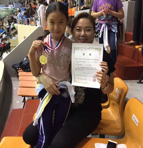 첫째 딸 유레아(왼쪽) 양이 2017년 8월에 초등학교 4학년 때 222m 트랙에서 첫 금메달을 수여할 때 2006년 토리노 동계올림픽 3000m 계주 금메달리스트 전다혜 선수(오른쪽)와 함께 기념 사진을 찍었다.(사진 제공 = 김민수 씨 본인)