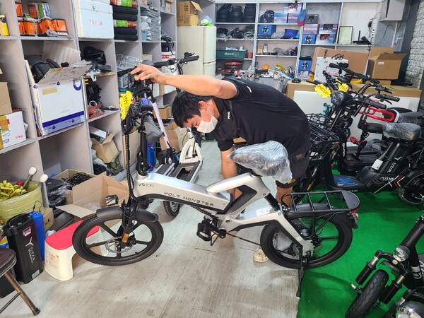 응웬 휴탕(41)씨가 전기 자전거의 페달을 굴려 보면서 모터를 점검하고 있다.