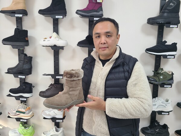 고려인 동포 4세인 루슬란(34)씨가 자신의 가게에서 판매중인 신발을 들고 포즈를 취하며 인터뷰 기념 사진 을 찍었다(사진 = 김종현 기자)