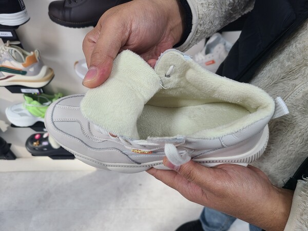 고려인 동포 4세인 루슬란(34) 씨가 자신의 가게에서 판매하는 제품 중 겨울을 맞아 잘 팔리는 제품을 선보이고 있다. 신발 속에 털이 있어 일반 신발보다 보온성이 좋아 보였다(사진 = 김종현 기자)