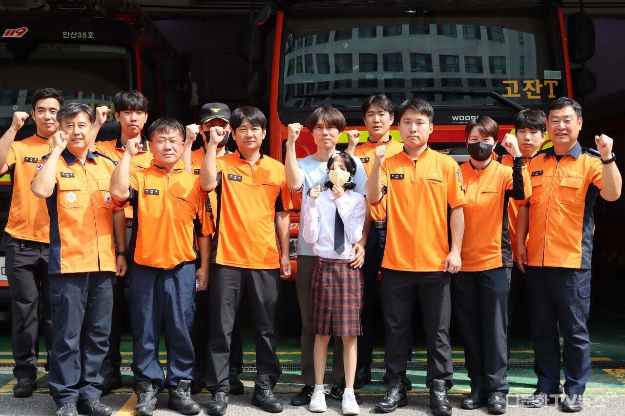 프로사카나양이 소방대원들과 함께 소방차량 앞에서 기념사진 촬영을 진행하고 있다. (사진제공 = 안산시외국인주민상담지원센터)